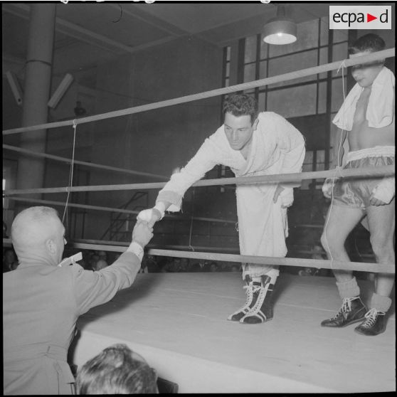 Un boxeur reçoit les félicitations du commandant Hennault, directeur des sports de la 10e RM (10e région militaire) lors de la demi-finale et finale interarmes de boxe au foyer civique.