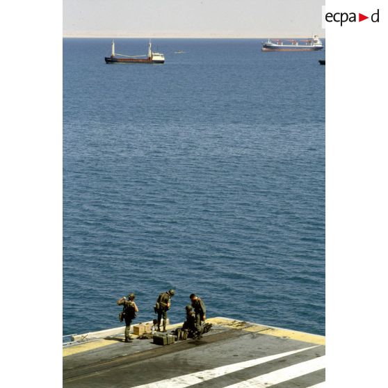 Soldats du 1er RI vérifiant leur équipement sur le pont d'envol du PA (porte-avions) Clemenceau dans le port de Yanbu.