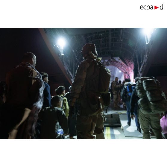 Des soldats encadrent l'embarquement de réfugiés à bord d'un avion-cargo A400 M à l'aéroport de Kaboul, en Afghanistan.