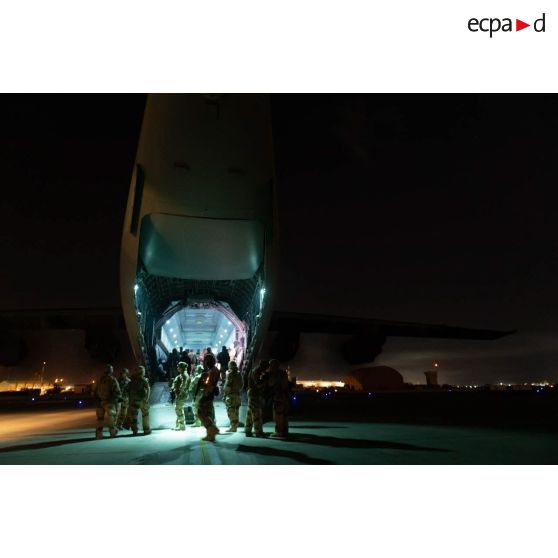 Des soldats encadrent l'embarquement de réfugiés à bord d'un avion-cargo A400 M à l'aéroport de Kaboul, en Afghanistan.