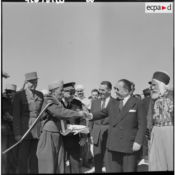 Robert Lacoste serre la main du Moghazni qui lui a présenté les ciseaux pour couper le ruban, inaugurant le bordj de la section administrative (SAS) de Sidi Ladjel.