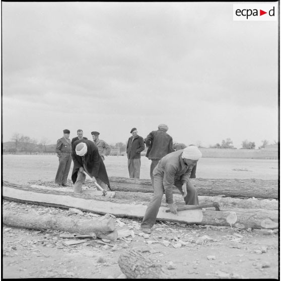 Des hommes coupant du bois.