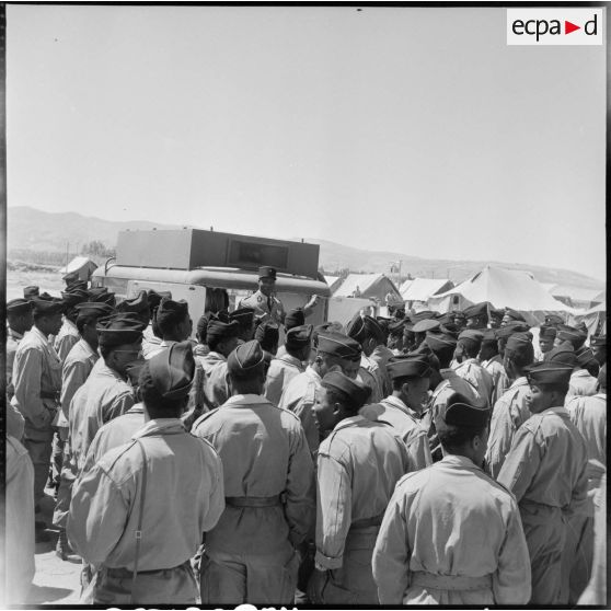 Devant le camion de la radiodiffusion militaire, les soldats de la France d'Outre-mer envoient des messages à leur famille.