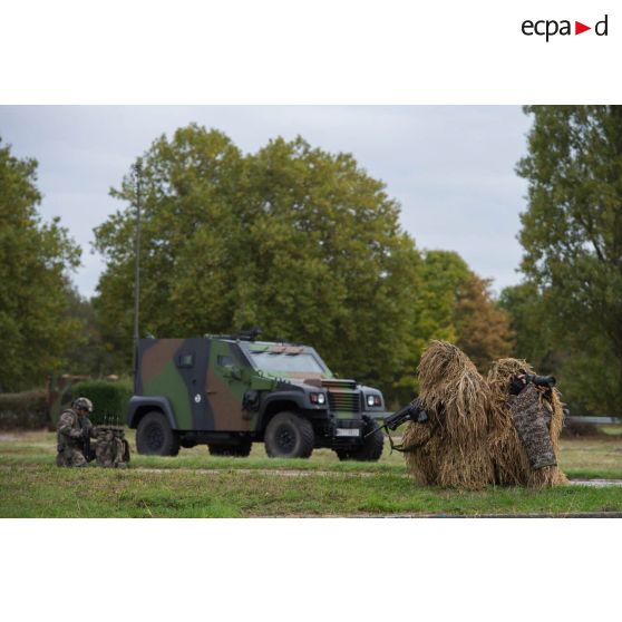 Hommes camouflés du 13e RDP (régiment de dragons parachutistes) autour d'un PVP (petit véhicule protégé) du 54e RTrs (régiment de transmissions) lors de la présentation des savoir-faire de l'armée de Terre à Satory.