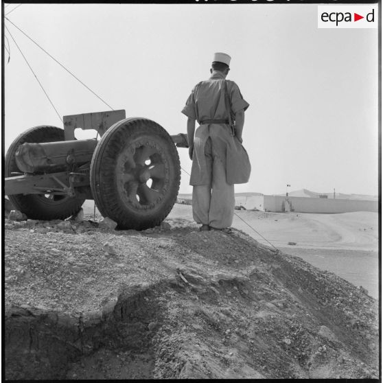 Un légionnaire et un canon de 75 mm Mle 1897 face à Fort Flatters.