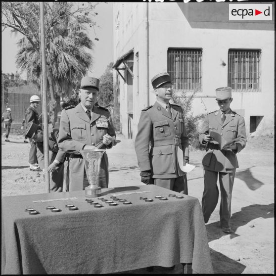 Le général Salan et le colonel Marquet devant la table où se trouvent les prix.