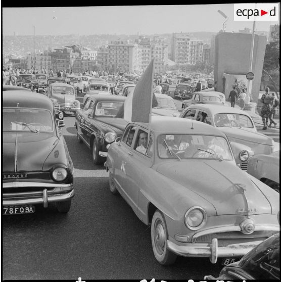 Quelques voitures pavoisées dans les rues d'Alger.