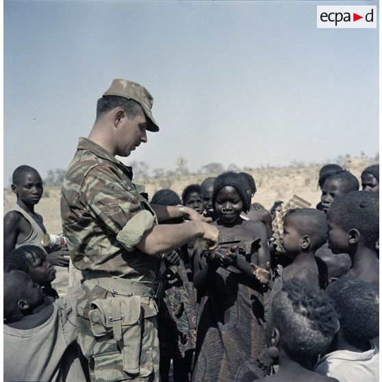 Un soldat français distribue du pain à des enfants tchadiens pendant une halte.