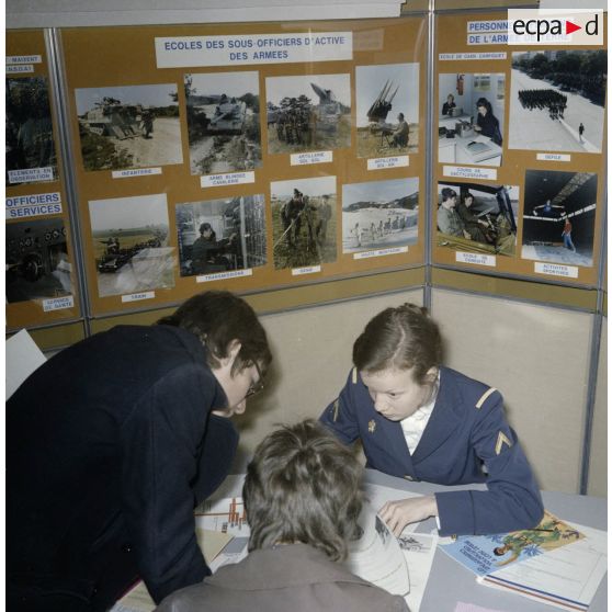 Une hôtesse accueille des étudiants sur un espace du stand de l'exposition Jeunesse 1976, dans l'ancienne gare de la Bastille à Paris.