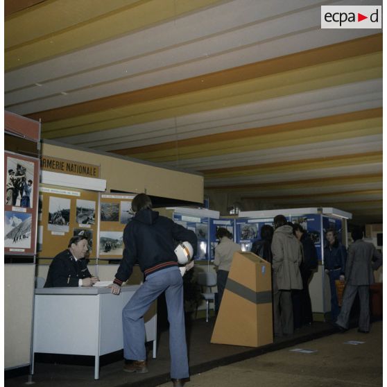 Un homme accueille un étudiant sur un espace du stand de l'exposition Jeunesse 1976, dans l'ancienne gare de la Bastille à Paris.