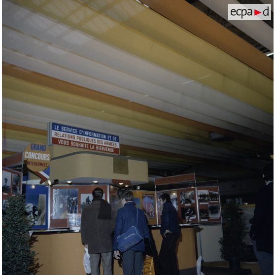 Etudiants devant le stand du Service d'information et de relations publiques des armées, à l'exposition Jeunesse, dans l'ancienne gare de la Bastille à Paris.