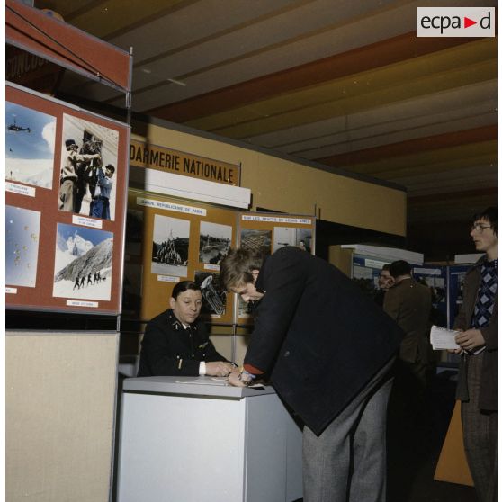 Un étudiant rempli un formulaire sur le stand de l'exposition Jeunesse, dans l'ancienne gare de de la Bastille.