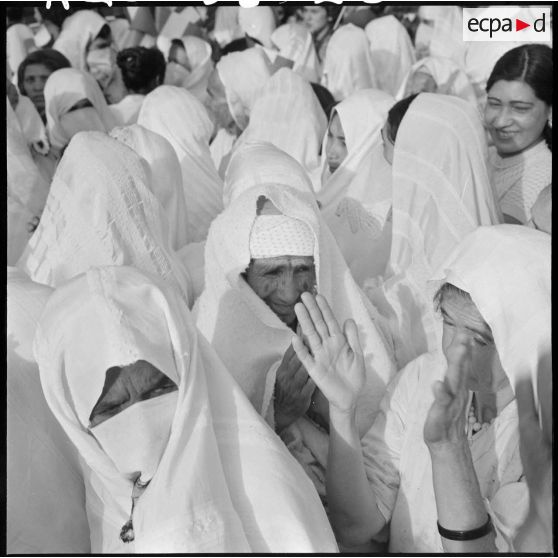 Des femmes applaudissent parmi la foule, lors d'une grande manifestation en l'honneur des femmes au forum d'Alger.