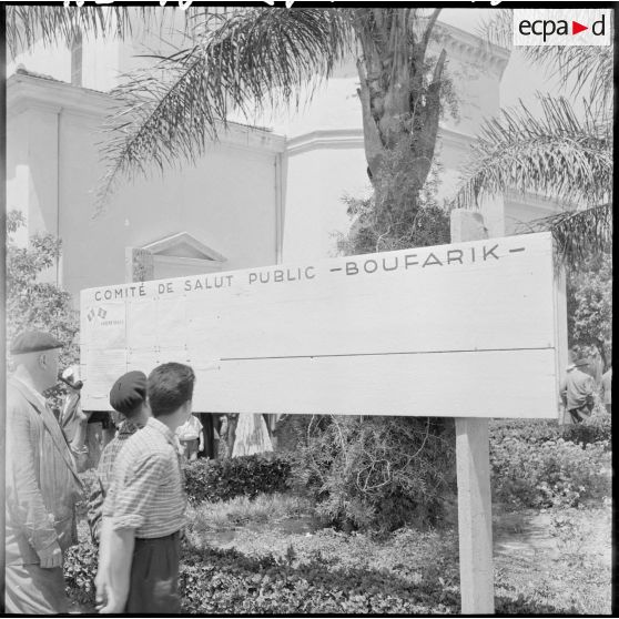 Sur la place de la mairie de Boufarik, le panneau portant la liste du comité de salut public de la ville.