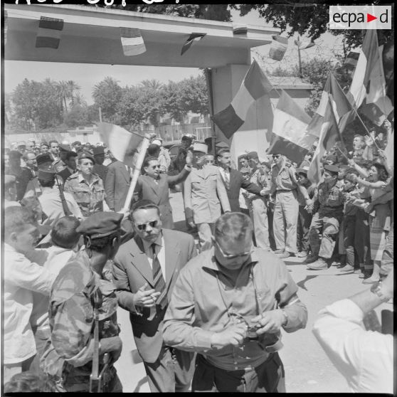 Jacques Soustelle fortement acclamé lève les bras pour répondre aux ovations de la foule.