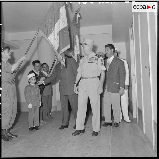 Le général Raoul Salan et Jacuqes Soustelle s'adressant à un enfant en uniforme, au gouvernement général de l'Algérie.