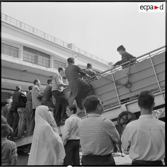 Une femme assiste au débarquement dans le port d'Alger.