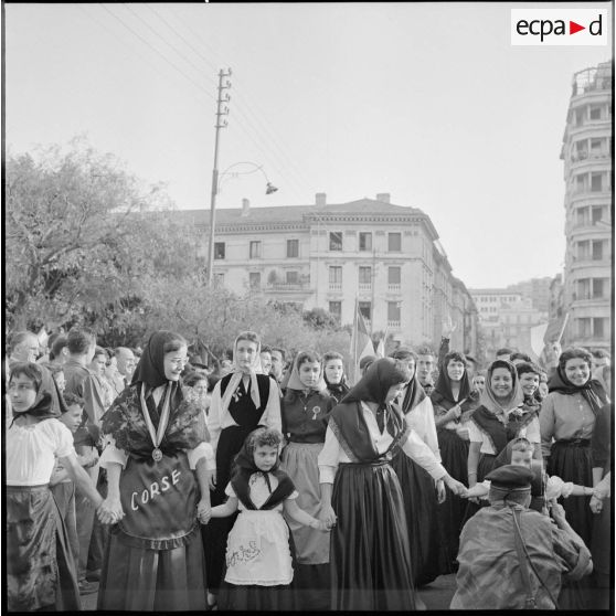 Les représentants de la Corse en costume traditionnel défilent dans les rues d'Alger, sous la caméra de l'opérateur François Bel.