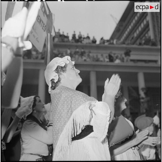 Portrait d'une femme applaudissant parmi la foule, au gouvernement général de l'Algérie à Alger.