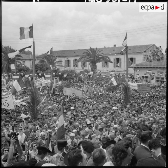 Tizi Ouzou. La foule pendant qu'un avion lance des petits drapeaux tricolores.