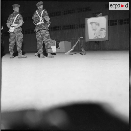 Aïn Arnat. Deux soldats regardent une cérémonie sur un écran.