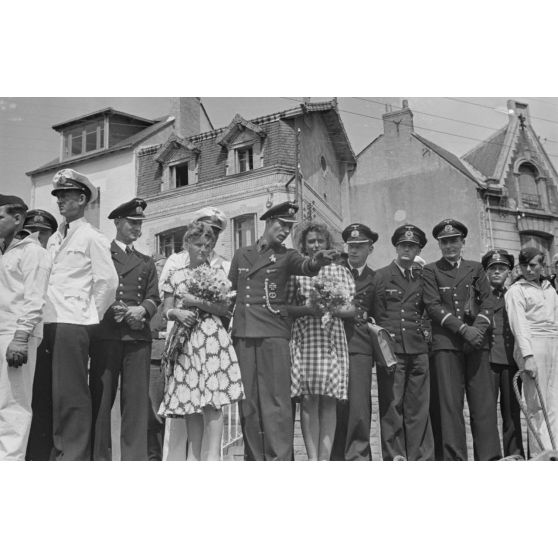 Sur le quai du port de Saint-Nazaire, des officiers de la Kriegsmarine et des jeunes femmes lors de l'arrivée du sous-marin U-203.