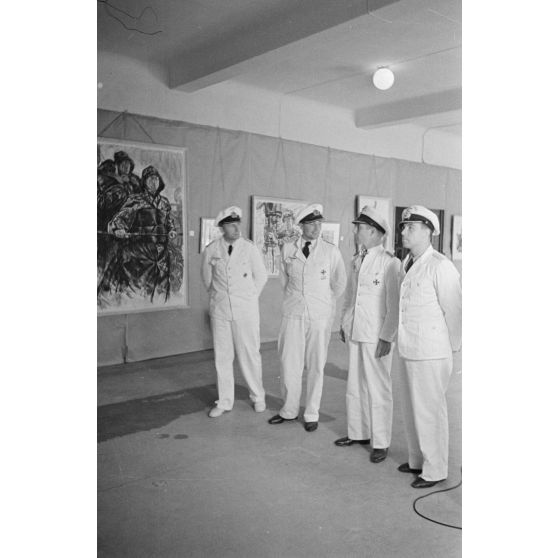 Guidés par les reporters Heinrich Schwich et  Lothar-Günther Buchheim, les Kapitänleutnant Jost Metzler et Herbert Kuppisch visitent une exposition de dessins et de peintures à l'hôtel Royal de La Baule.