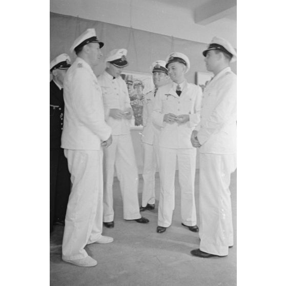 Guidés par les reporters Heinrich Schwich et Lothar-Günther Buchheim, les Kapitänleutnant Jost Metzler, Klaus Korth et Herbert Kuppisch visitent une exposition de dessins et de peintures à l'hôtel Royal de La Baule.