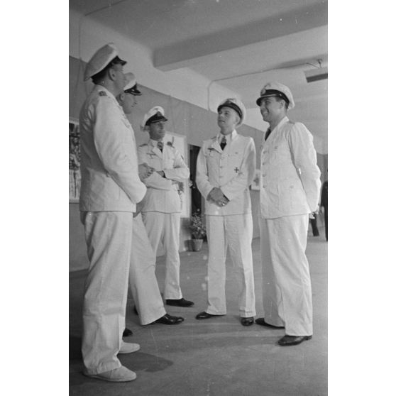 Guidés par les reporters Heinrich Schwich et Lothar-Günther Buchheim, les Kapitänleutnant Jost Metzler, Klaus Korth et Herbert Kuppisch visitent une exposition de dessins et de peintures à l'hôtel Royal de La Baule.