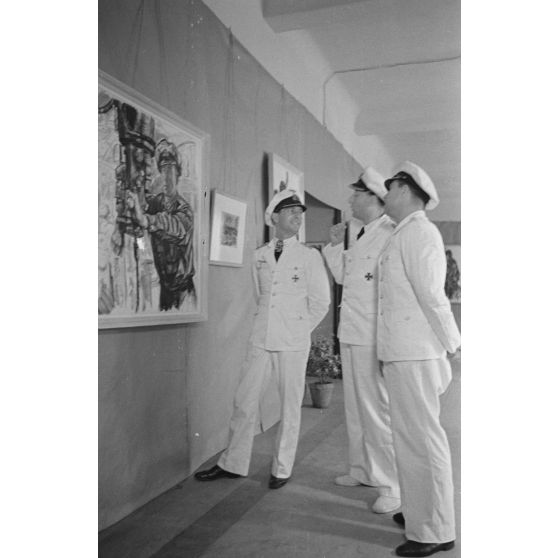 Guidé par les reporters Heinrich Schwich et  Lothar-Günther Buchheim, le Kapitänleutnant  Herbert Kuppisch visite une exposition de dessins et de peintures à l'hôtel Royal de La Baule.