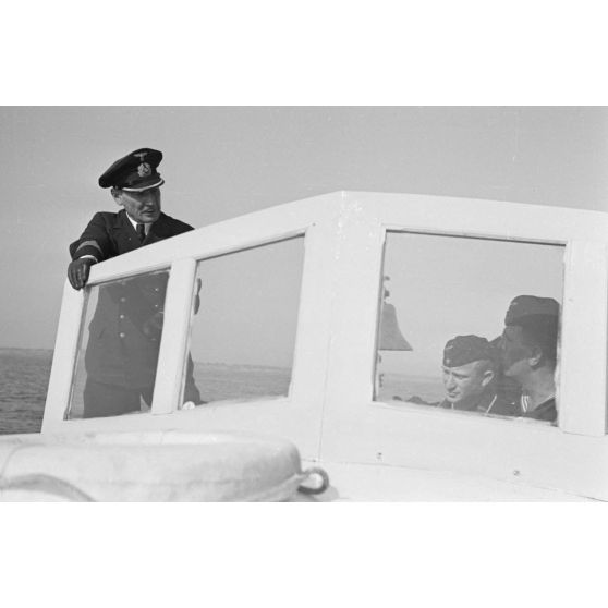 Près du port de Saint-Nazaire, des marins se rapprochent du sous-marin U-552 à bord d'une petite embarcation.