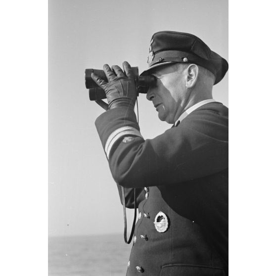 Près du port de Saint-Nazaire, des marins se rapprochent du sous-marin U-552 à bord d'une petite embarcation.