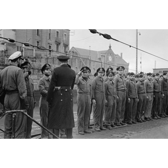 Le capitaine de corvette (Korvettenkapitän) Herbert Sohler, représentant de la 7.Unterseebootsflottille passe en revue l'équipage du U-74 en présence de son commandant Eitel-Friedrich Kentrat.