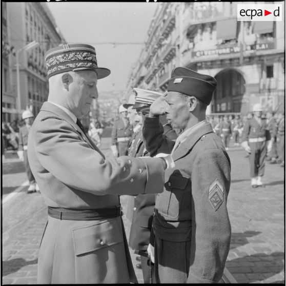 Le général Raoul Salan décore un brigadier-chef du 411ème régiment d'artillerie (RA) de la médaille militaire.