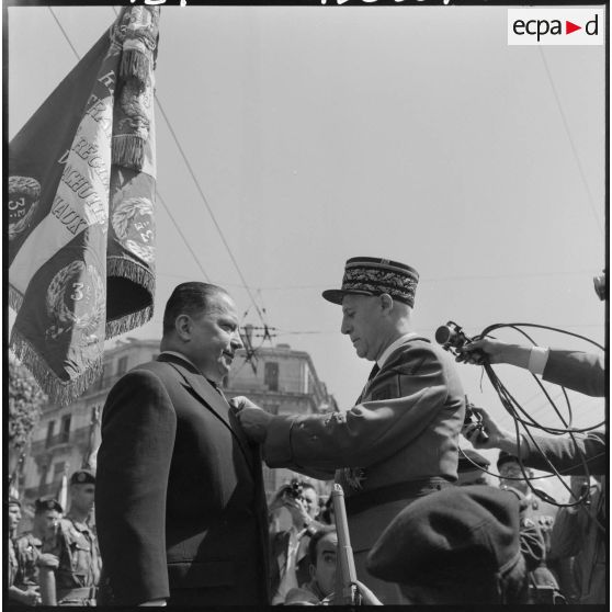 A l'issue du défilé, et avant de se rendre au monument aux morts, le général d'armée Raoul Salan, remet à Robert Lacoste, la croix de la valeur militaire avec palme.