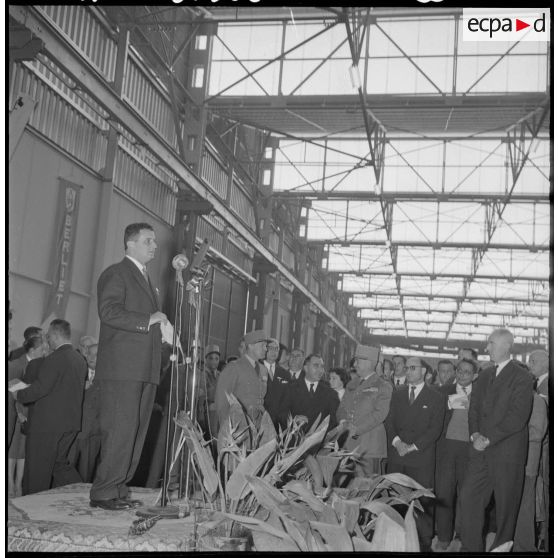 Des autorités civiles et militaires visitent un site de montage de véhicules.