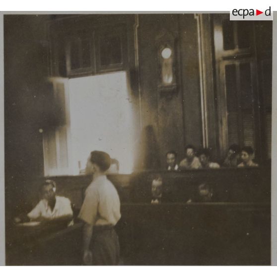 Un homme debout dans la salle du palais de justice où les criminels de guerre japonais sont jugés.