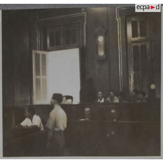 Un homme debout dans la salle du palais de justice où les criminels de guerre japonais passent en jugement.