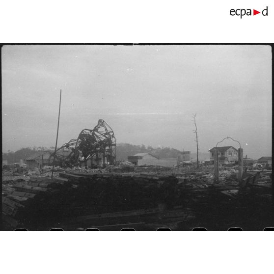 [Hiroshima, juin 1946. Les structures métalliques ont été tordues par la chaleur de la déflagration.]