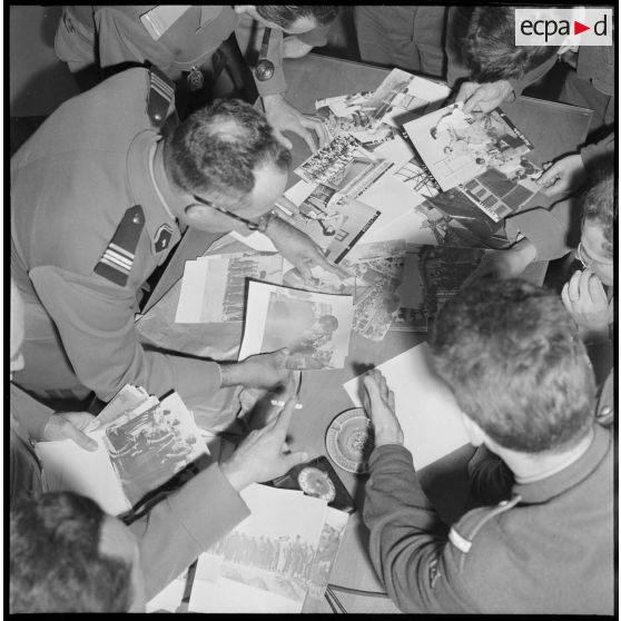 Algérie. 5e bureau. Des stagiaires officiers trient des photos pour la création d'une affiche de propagande.