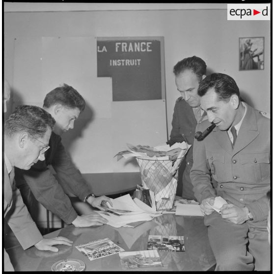 Algérie. 5e bureau. Des stagiaires officiers trient des photos pour la création d'une affiche de propagande.