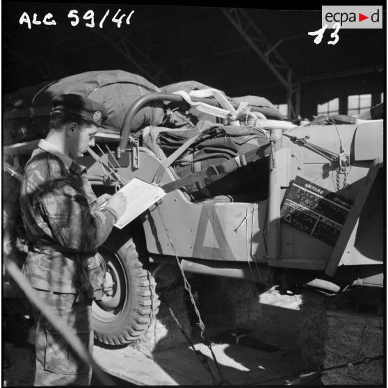 Sud algérien. Opération Violet. Un soldat inventorie le matériel et l'affectation d'une jeep.