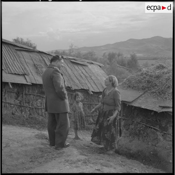 Valee. Le Lieutenant Bastien, officier du secteur de Philippeville, s'entretient avec une mère de famille du village.