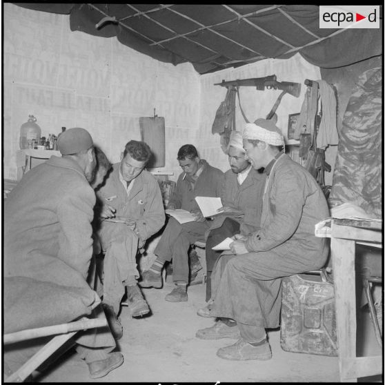 Monts Zouaiena. Dans la chambre, l'instituteur militaire enseigne au groupe d'autodéfense.