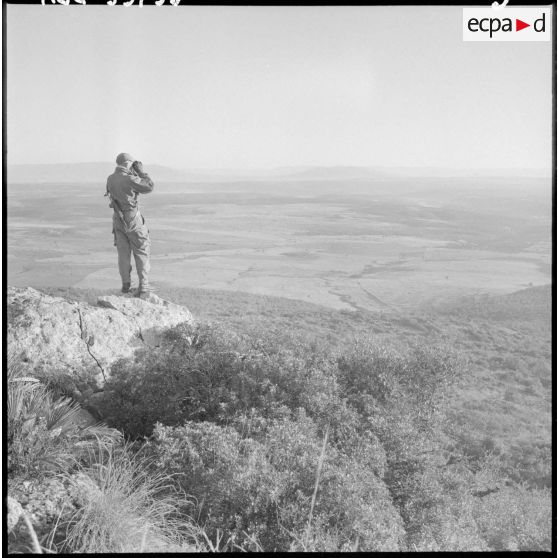 Opération dans la région de Sidi-Mimoun, monts de Saïda. Le colonel Bigeard regarde le terrain à l'aide de jumelles.