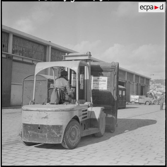 Port d'Alger. Chariot élévateur transportant un container de livres scolaires.