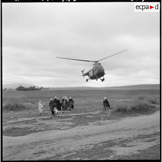 Région de Frenda. Des hélicoptères Sikorsky H-34 atterrissent dans un champ à côté de villageois.