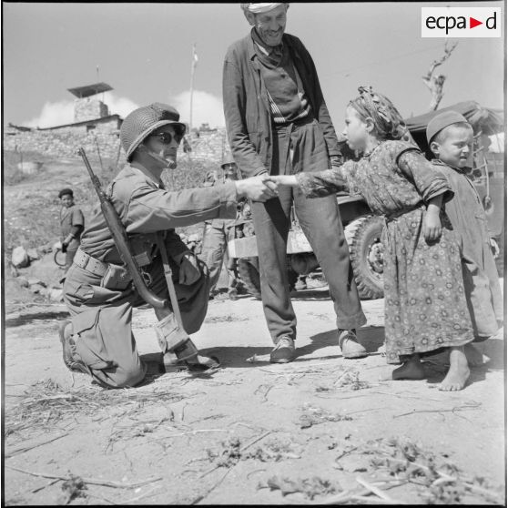 Boudjima. Un soldat serre la main d'une petite fille.