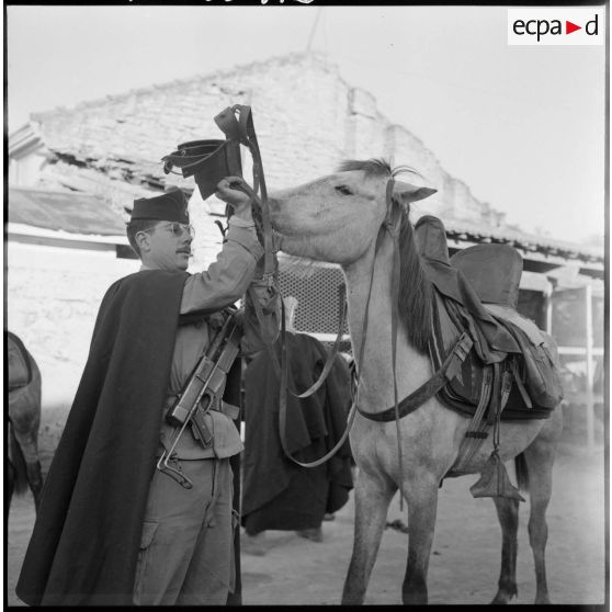 Ponteba. Le caporal classe 57 1/A prépare l'harnachement de son cheval pour le départ.