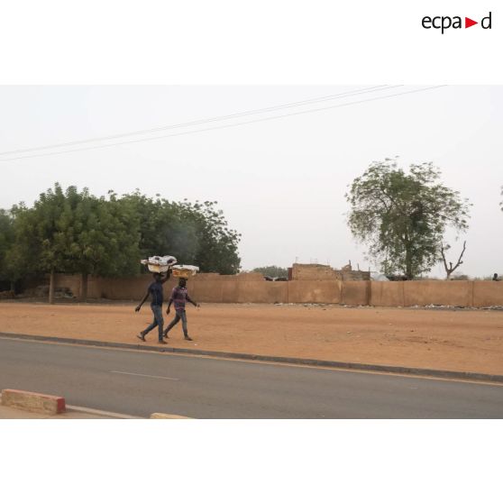 Des nigériens marchent dans une rue de leur village, au Niger.